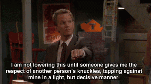a man in a suit and tie is pointing at someone