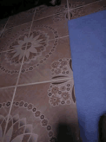 a close up of a tile floor with a floral pattern