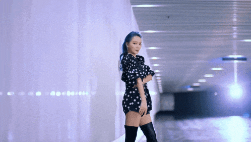 a woman with blue hair wearing a polka dot dress and thigh high boots