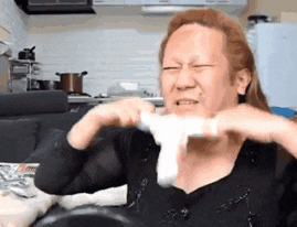 a man with red hair is holding a white object in front of his face ..