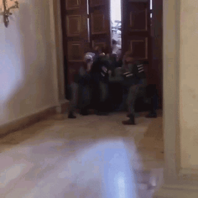 a group of soldiers are standing in a hallway in front of a door ..