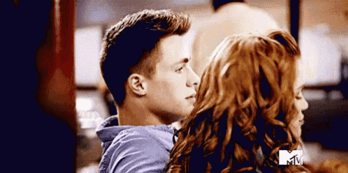 a man and a woman are standing next to each other in a room .