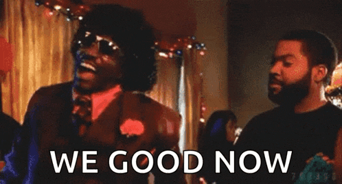 a man in a suit and tie is standing next to a man in a black shirt and says `` we good now '' .