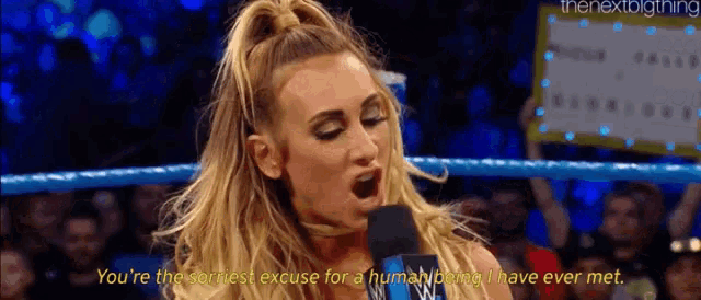 a woman in a wrestling ring is talking into a microphone and says you 're the worst excuse