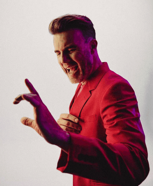 a man in a red suit is making a gesture with his hands
