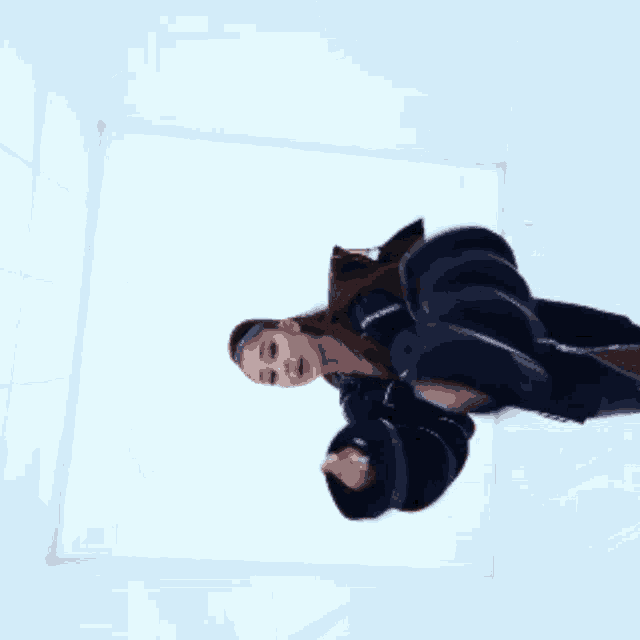 a woman in a black jacket is standing in a room with her arms outstretched