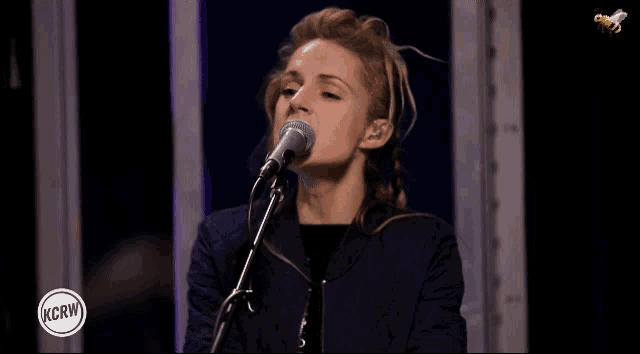 a woman singing into a microphone with the words kcrw on the bottom