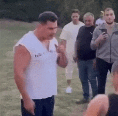 a group of men are standing in a grassy field .