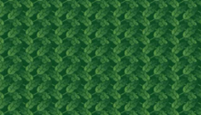 a piece of paper with a pattern of leaves and flowers is sitting in the grass .
