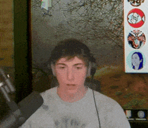 a young man wearing headphones and a white shirt is sitting in front of a microphone in front of a painting