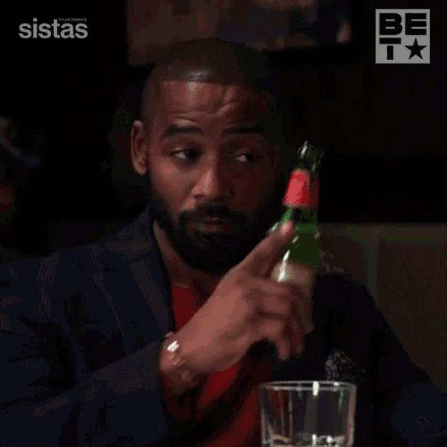 a man in a suit is holding a bottle of soda and says that 's a good question