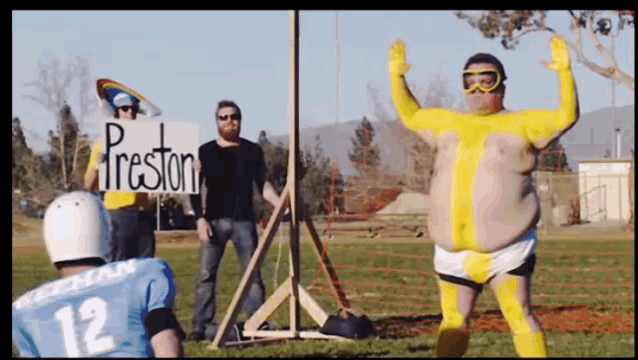 a man in a yellow outfit holds a sign that says fireston