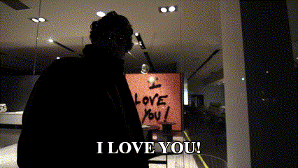 a man is standing in front of a sign that says i love you