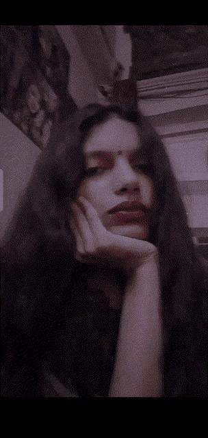 a woman with long dark hair and a red bindi on her forehead