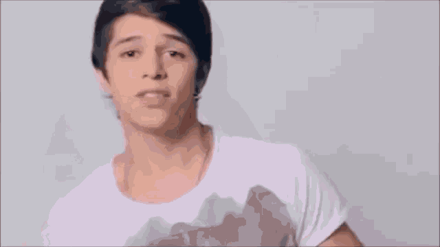 a young man is making a funny face with his hands .