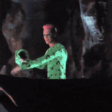 a person in a green shirt with a pink hat and green glasses