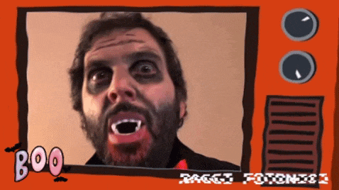 a man with vampire teeth is on a tv screen with the words boo written on it