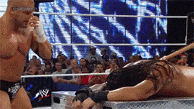 a man in a wrestling ring with a wwe logo on the wall