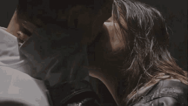 a woman is kissing a man on the cheek