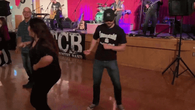 a man and woman are dancing in front of a sign that says cb