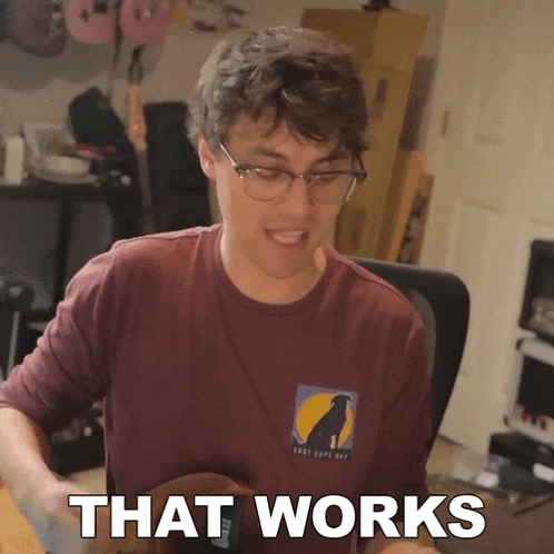 a man wearing glasses and a maroon shirt that says " that works "