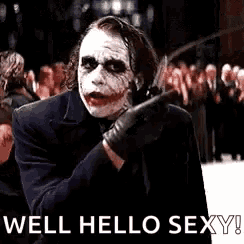 the joker from the movie the dark knight is holding a knife and pointing at the camera .