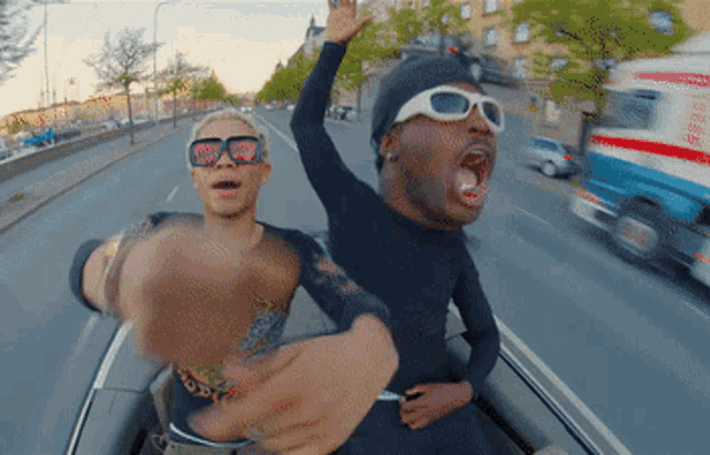 a man wearing sunglasses with hearts on them is riding with another man