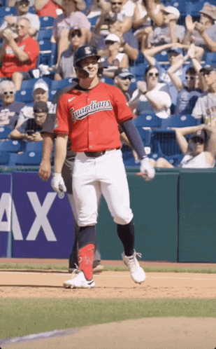 a baseball player wearing a red guardians jersey walks on the field