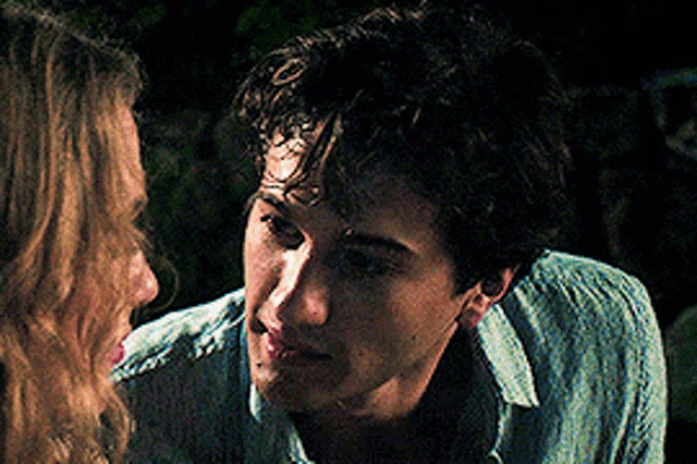 a man and a woman are looking at each other with their eyes closed .