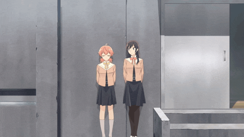 two girls are standing next to each other in front of a wall