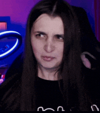 a woman with long hair is making a funny face while sitting in front of a ring light .