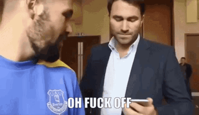 a man in a blue and yellow everton shirt says oh fuck off