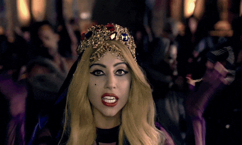 lady gaga wearing a crown and purple gloves
