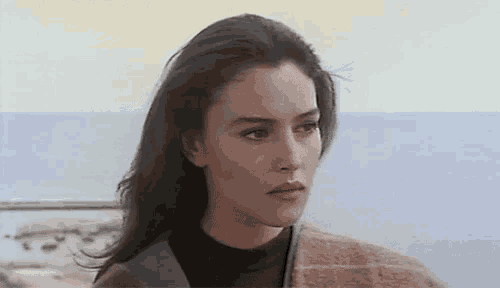 a close up of a woman 's face looking at the ocean .