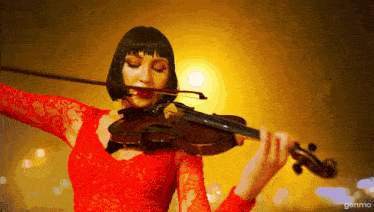 a woman in a red dress playing a violin