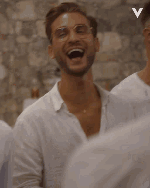 a man in a white shirt holds a green bottle