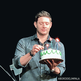 a man is lighting a candle on a cake with the word impala on the bottom right