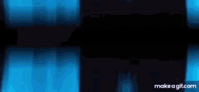 a person is standing in a dark room with blue lights coming out of the ceiling .