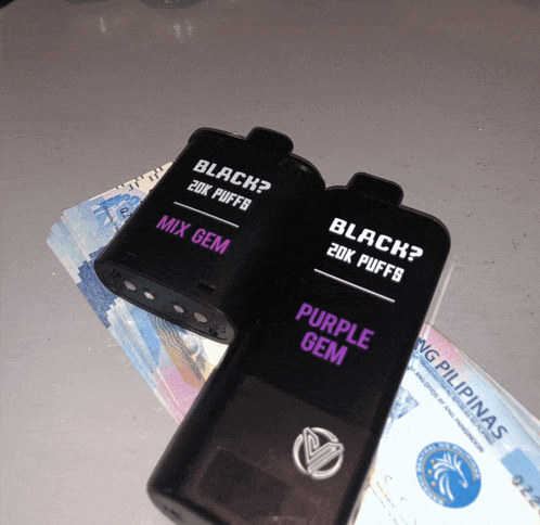 a purple gem and a black gem are on a pile of money
