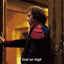 a man in a red and blue jacket is standing in front of a door and says god on high