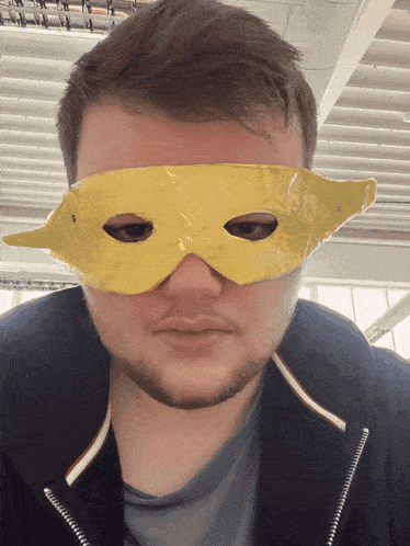 a man with a beard wears a yellow mask on his eyes