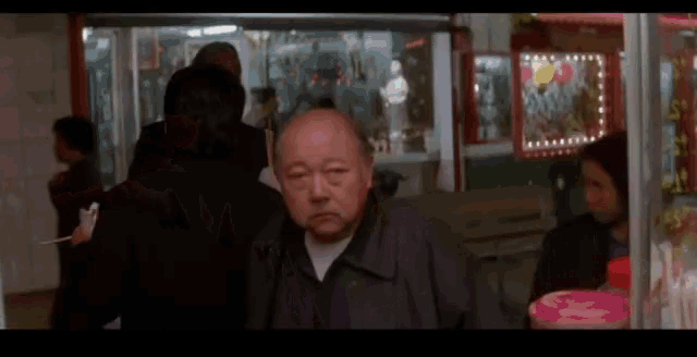 a man in a black jacket is standing in a store