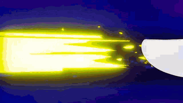 a yellow light is coming out of a white object against a blue background .