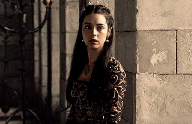 a woman in a black and gold dress with a crown on her head