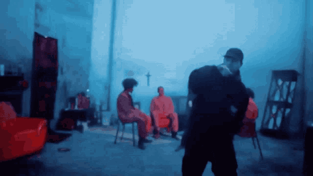 a blurry picture of a group of people in a room with a cross on the wall