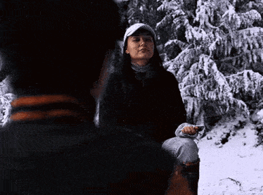 a man and a woman are sitting in the snow .