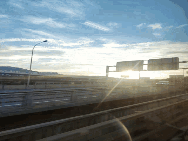 the sun shines brightly through the clouds over a highway