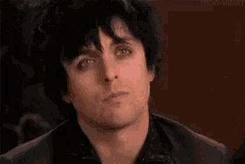 a close up of a man 's face with a caption that says `` make it a green day '' .