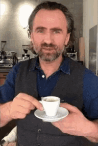 a man is holding a cup of coffee in his hand