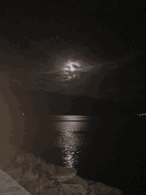 a full moon over a body of water
